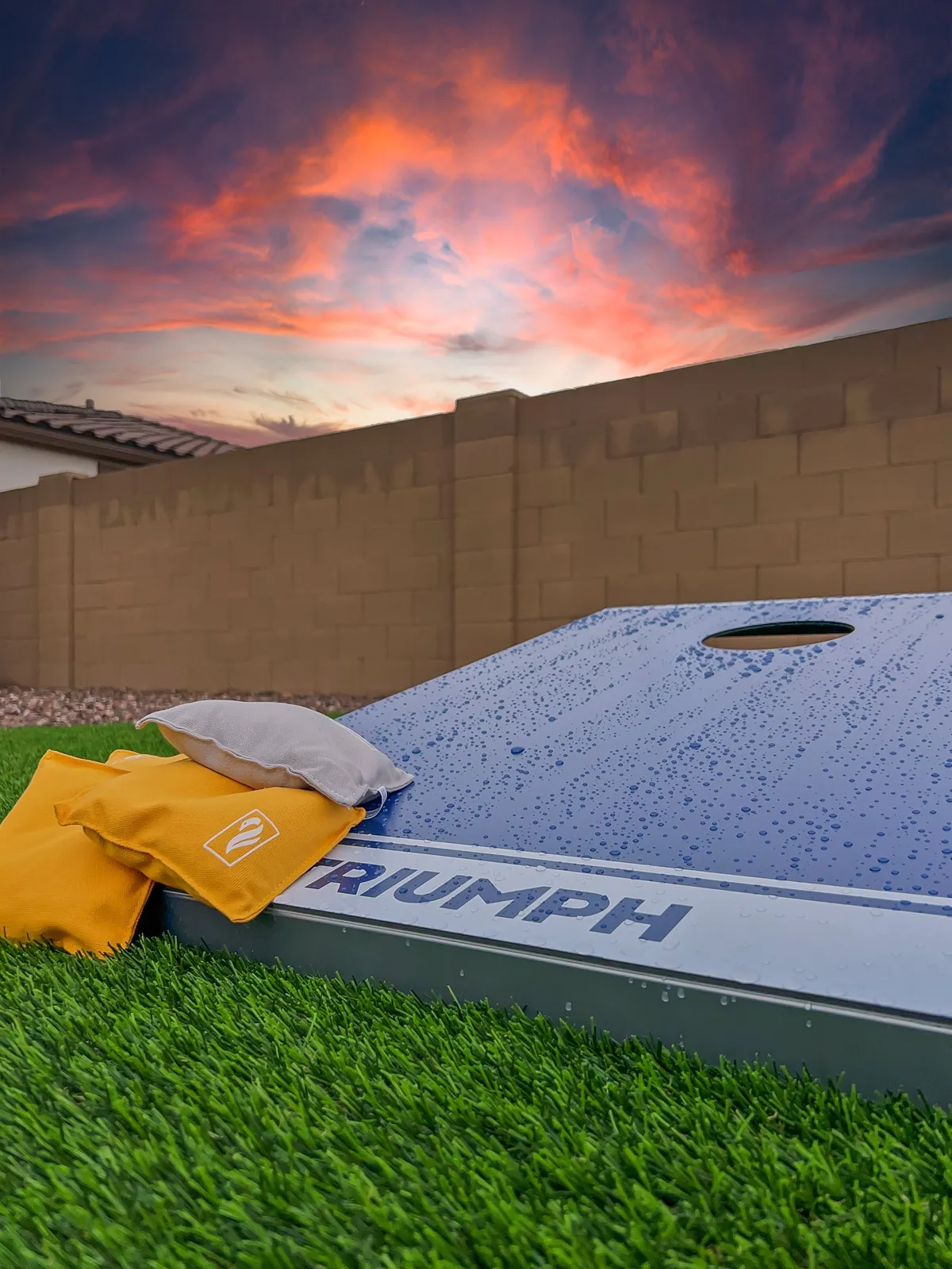 An inviting exterior scene at sunset, featuring a cornhole game set up on the lawn against a vibrant sky. The mood is cheerful and lively, ideal for friendly competition, social gatherings, and making lasting memories in the community.