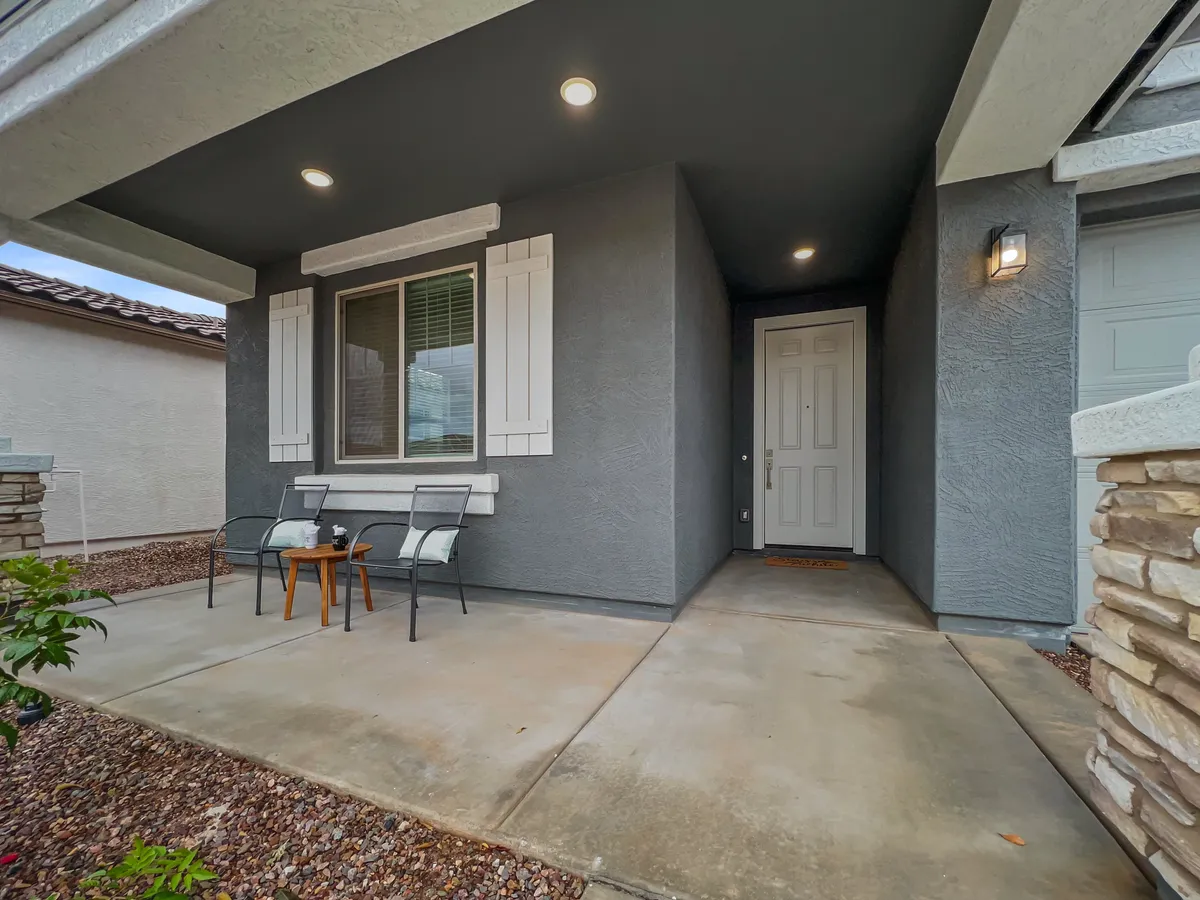 The image showcases the welcoming front entrance of the home, featuring a stylish front door, a cozy seating area perfect for enjoying quiet moments, and decorative stonework that adds character and curb appeal. The outdoor setting invites a sense of arrival and comfort.