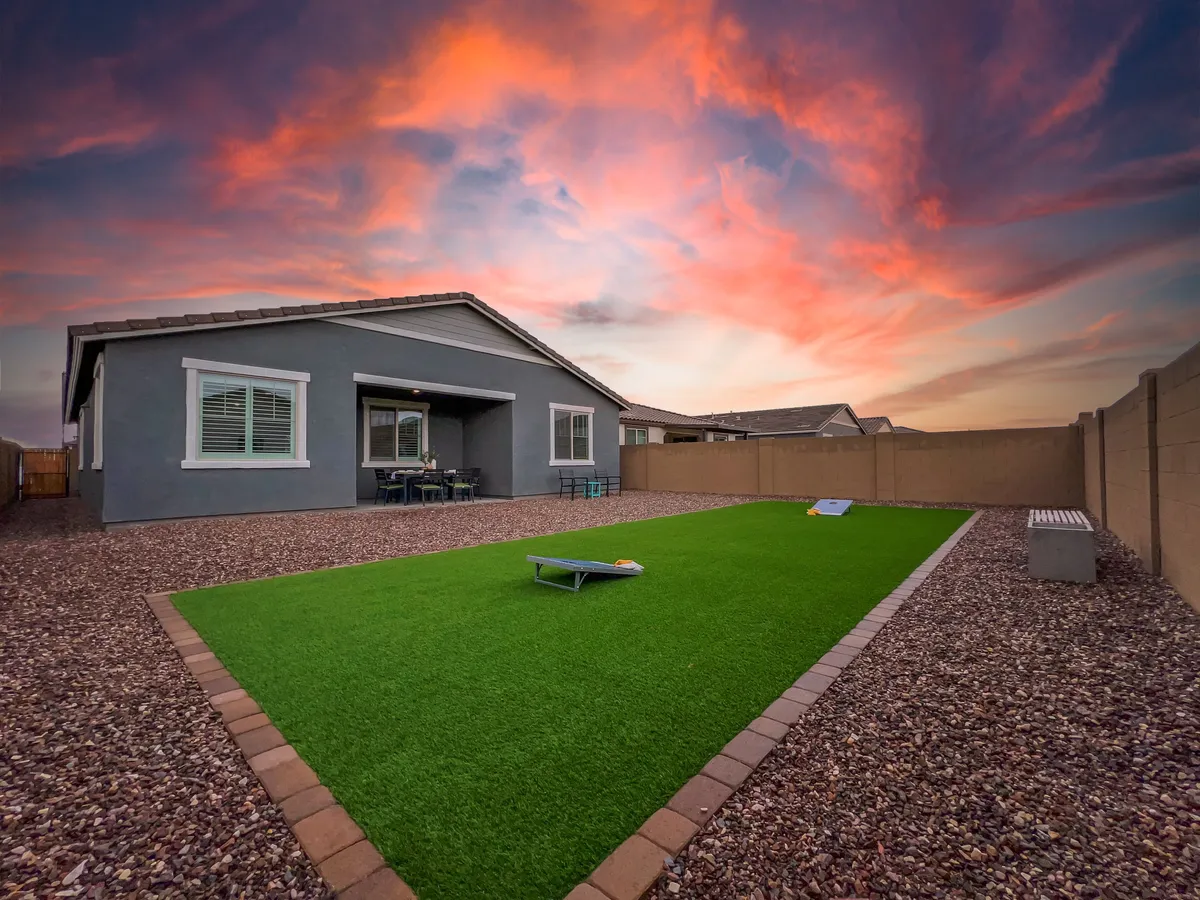 A vibrant green lawn with a comfortable patio set under an open sky. The area encourages outdoor dining, socializing, and enjoying sunset views—ideal for unwinding after work or connecting with neighbors.